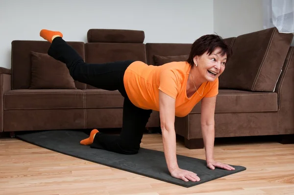 Mulher idosa se exercitando em casa — Fotografia de Stock