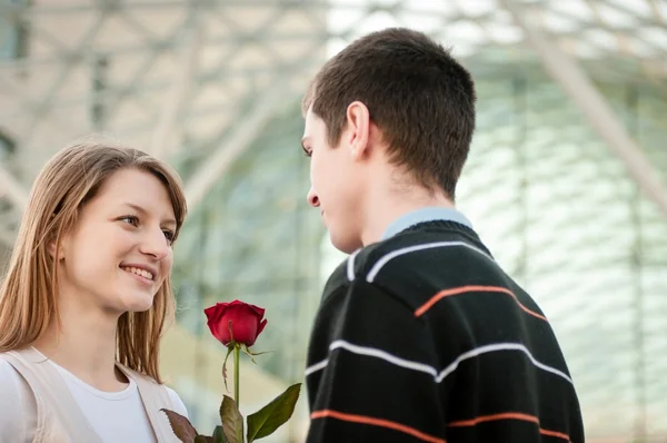Homem entregando uma flor à mulher — Fotografia de Stock