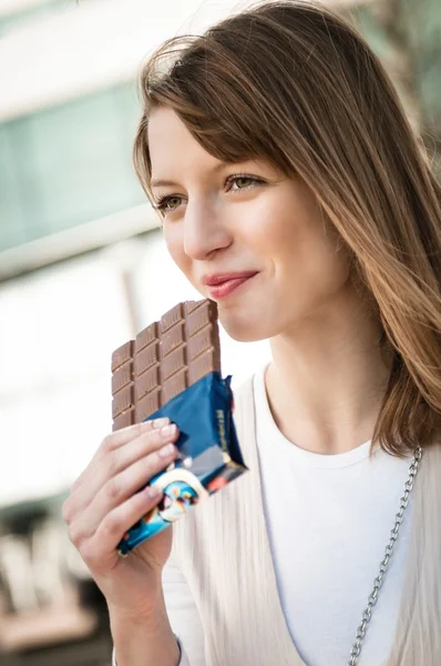 Молодая женщина ест шоколад — стоковое фото