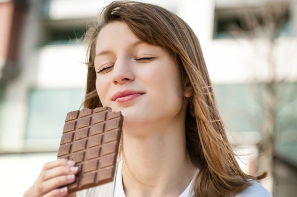 Jeune femme mangeant du chocolat — Photo