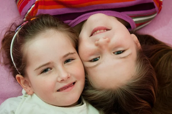Hermanas sonrientes acostadas en la cama —  Fotos de Stock