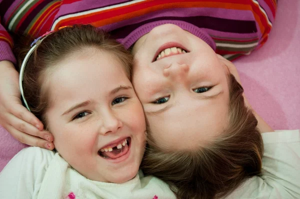 Hermanas sonrientes acostadas en la cama —  Fotos de Stock