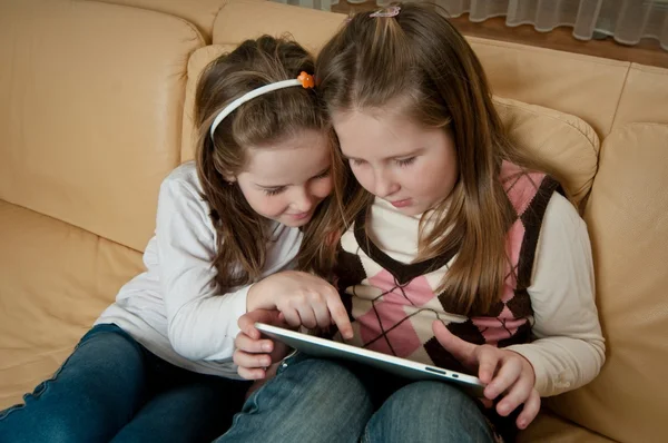 Systrarna leker med tablett — Stockfoto