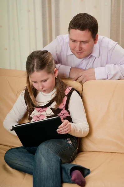 父亲看着女儿在平板电脑上玩 — 图库照片