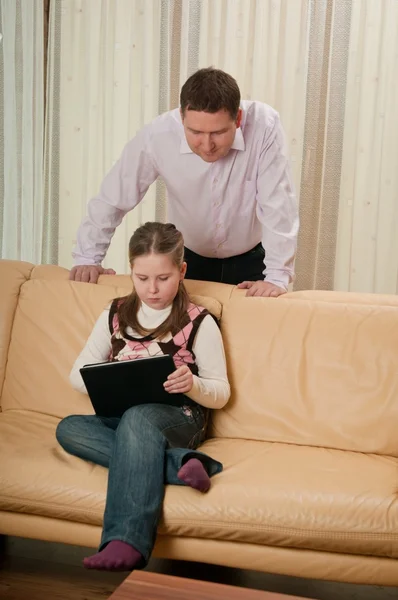 Father watches as daughter playing on the tablet — Stock Photo, Image