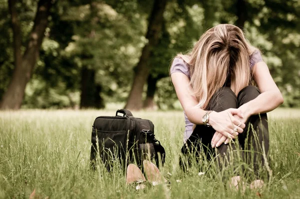 Depressed business woman siting in grass — Stock Photo, Image