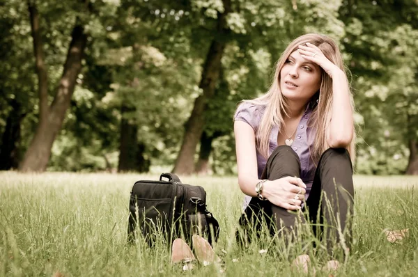 Деловая женщина сидит в траве — стоковое фото