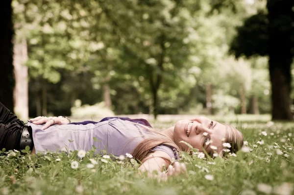 Kobieta, leżąc w świeżej zielonej trawie — Zdjęcie stockowe