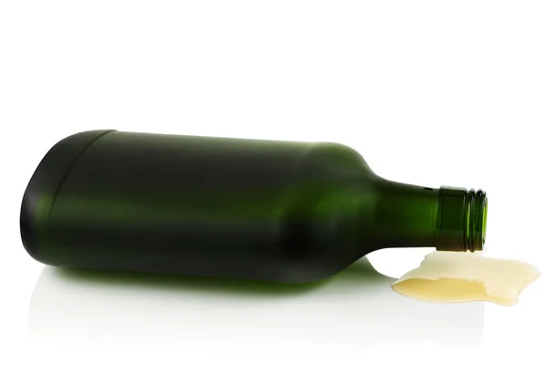 Deitado de lado uma garrafa de licor de um copo verde . — Fotografia de Stock