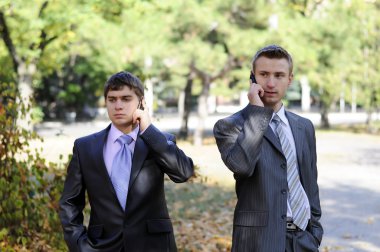 Two businessmen talking on the phone clipart