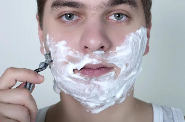 Shaving man on a gray background — Stock Photo, Image
