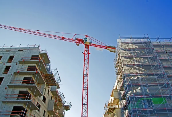 Crane surrounded two buildings under construction, — Stock Photo, Image