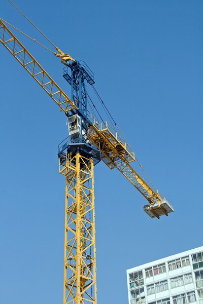 Crane in action on a blue sky and building