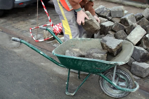 Ein Mann transportiert Steine in einer Schubkarre — Stockfoto
