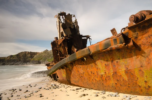 Old abandoned boat stranded on the beach Stock Photo