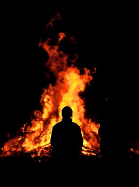 şenlik ateşi önünde genç bir kadın