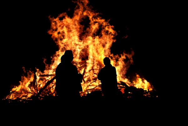 Three persons in front of bonfire — Stock Photo, Image