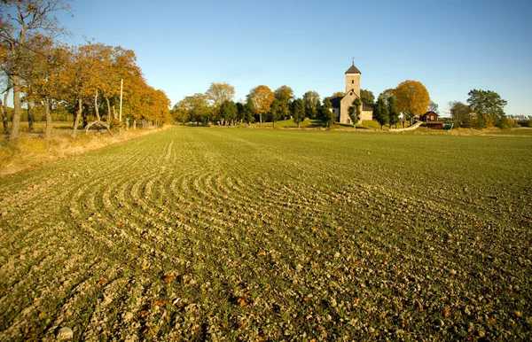 Plowed field and church — Stock Photo, Image