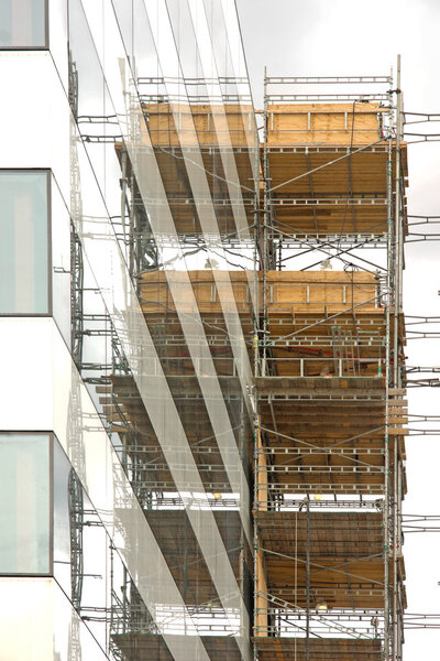 Scaffolding reflected in the facade of an office building