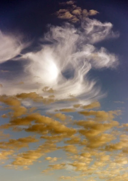 Nuvens brancas e amarelas em um céu azul — Fotografia de Stock