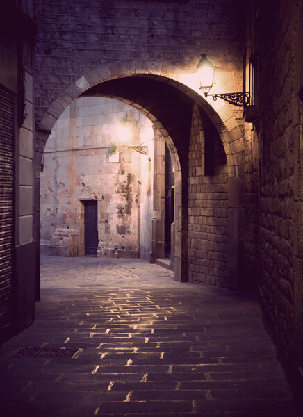 Narrow street with archway in the Old Town of Barcelona, Spain.