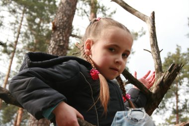 Autumn little girl play outside in a forest clipart