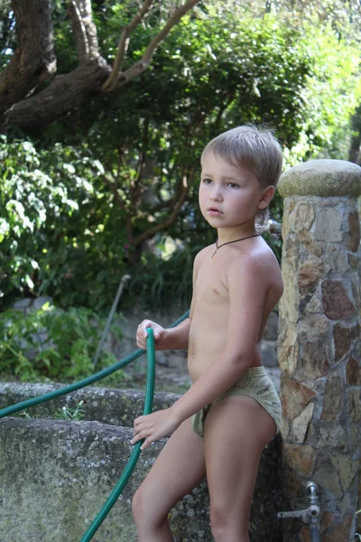 Roztomilé batole chlapec zalévání rostlin v zahradě — Stock fotografie