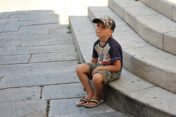 A small boy sitting on stairs — Stock Photo, Image