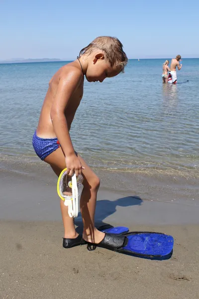 Ein süßer kleiner Junge, der Spaß am Strand hat Stockbild