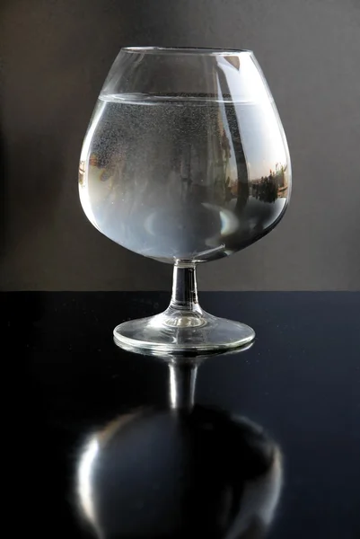 Vatten i glas på svart bakgrund som "still life" — Stockfoto