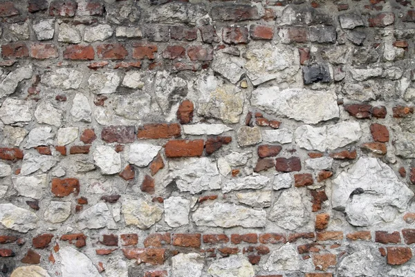 Forntida stonewall byggda av tegel och sten i krakow — Stockfoto
