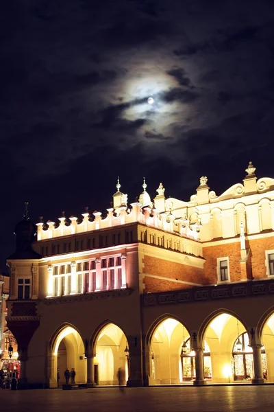 Krakow 's Cloth Hall at night and moon above — стоковое фото