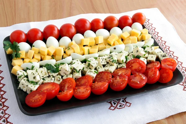 Peynirler, Bıldırcın yumurta ve domates sırasında parti plaka üzerinde — Stok fotoğraf