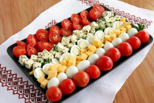 Салат с помидорами черри, перепелиными яйцами и двумя видами сыра — стоковое фото