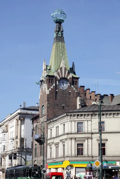 Věž s hodinami a zeměkoule starobylého domu v Krakově — Stock fotografie