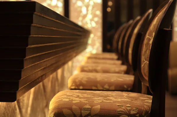Assentos de madeira em um bar — Fotografia de Stock