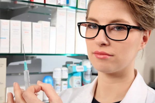 Young pharmacist holding an injection — Stock Photo, Image
