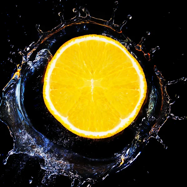 Fatia de laranja cai na água. — Fotografia de Stock