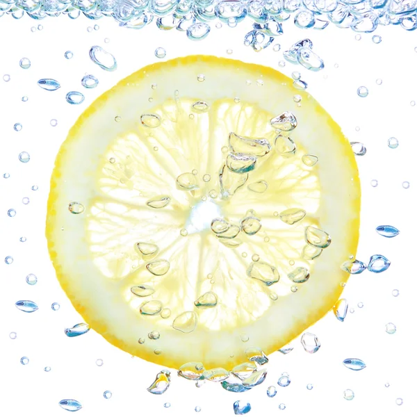 Limão em um líquido com bolhas. sobre um fundo branco. — Fotografia de Stock