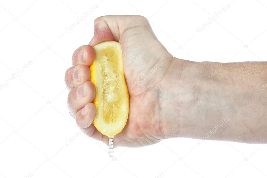 The hand squeezes a lemon. On a white background.