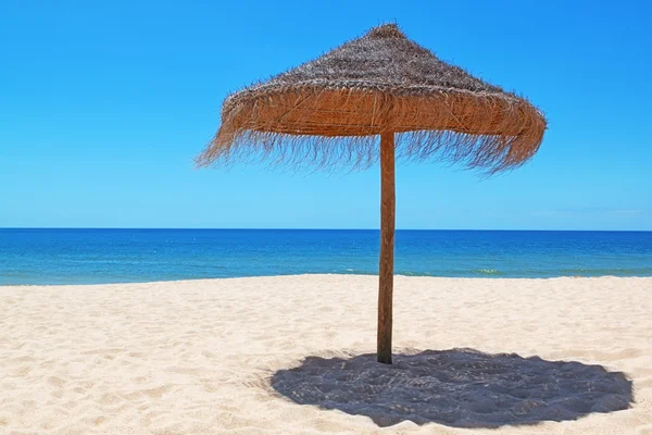 Guarda-chuva de madeira na bela praia portuguesa. — Fotografia de Stock