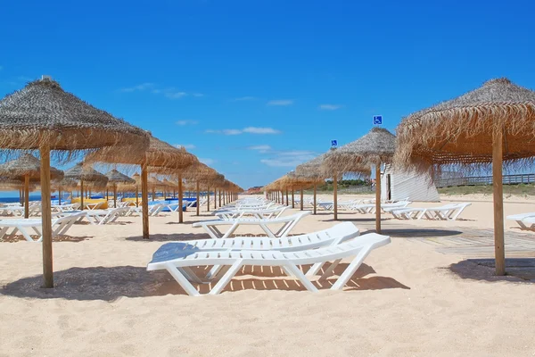 Beach loungers and umbrellas on the sea. Portugal. Vila Moura. — Stock Photo, Image
