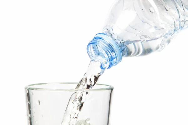 Schoon water stroomt in de fles. op een witte achtergrond. — Stockfoto