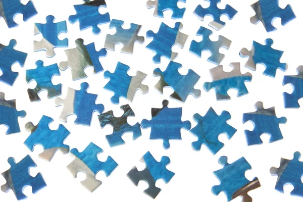 Puzzles dispersed on a white background. — Stock Photo, Image