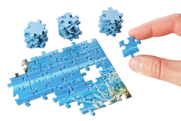El puzzle falta en los dedos sobre un fondo blanco. —  Fotos de Stock