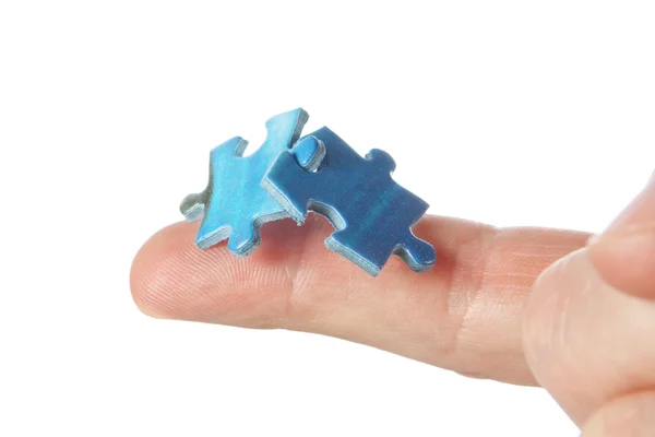 Connecting two puzzles on your finger. On a white background. — Stock Photo, Image