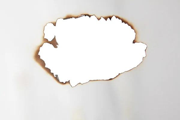 Burnt a hole in a sheet of paper. — Stock Photo, Image