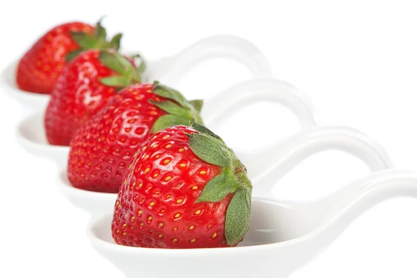 Group of strawberries on a porcelain spoon. — Stock Photo, Image