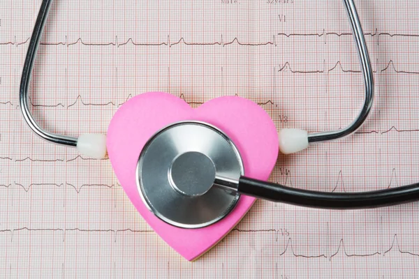 Стетоскоп и сердца на фоне кардиограммы. — стоковое фото
