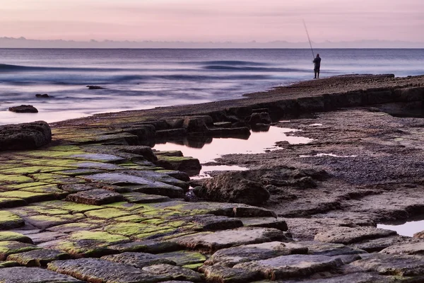 Pescador en el mar con caña. — Foto de Stock